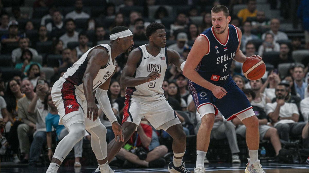 Nikola Jokic of Serbia guarded by two Team USA players