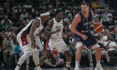 Nikola Jokic of Serbia guarded by two Team USA players