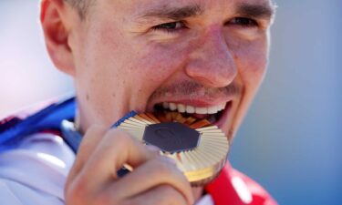 Tom Pidcock celebrates his gold medal.