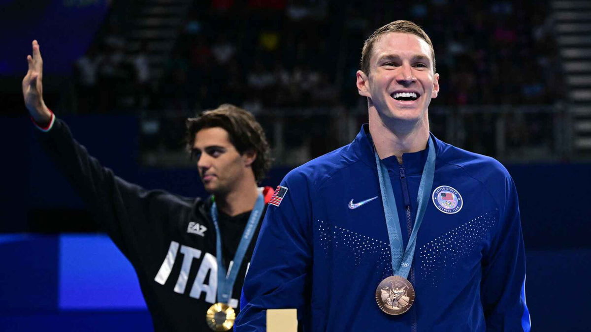 Ryan Murphy (R) reacts to learning the sex of his first child after the medal ceremony of the men's 100m backstroke at the Paris Olympics.