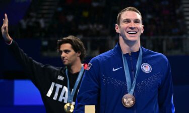 Ryan Murphy (R) reacts to learning the sex of his first child after the medal ceremony of the men's 100m backstroke at the Paris Olympics.