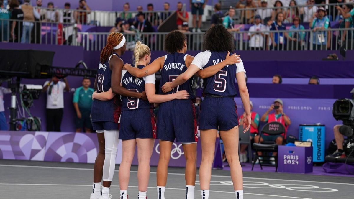 Members of the U.S. women's 3x3 basketball team stand during the national anthem