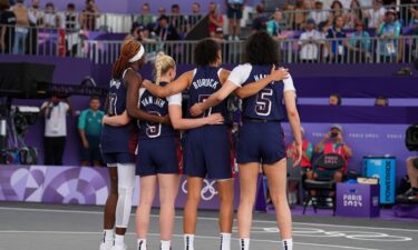 Members of the U.S. women's 3x3 basketball team stand during the national anthem