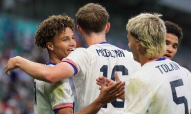 USMNT players celebrate after scoring a goal.