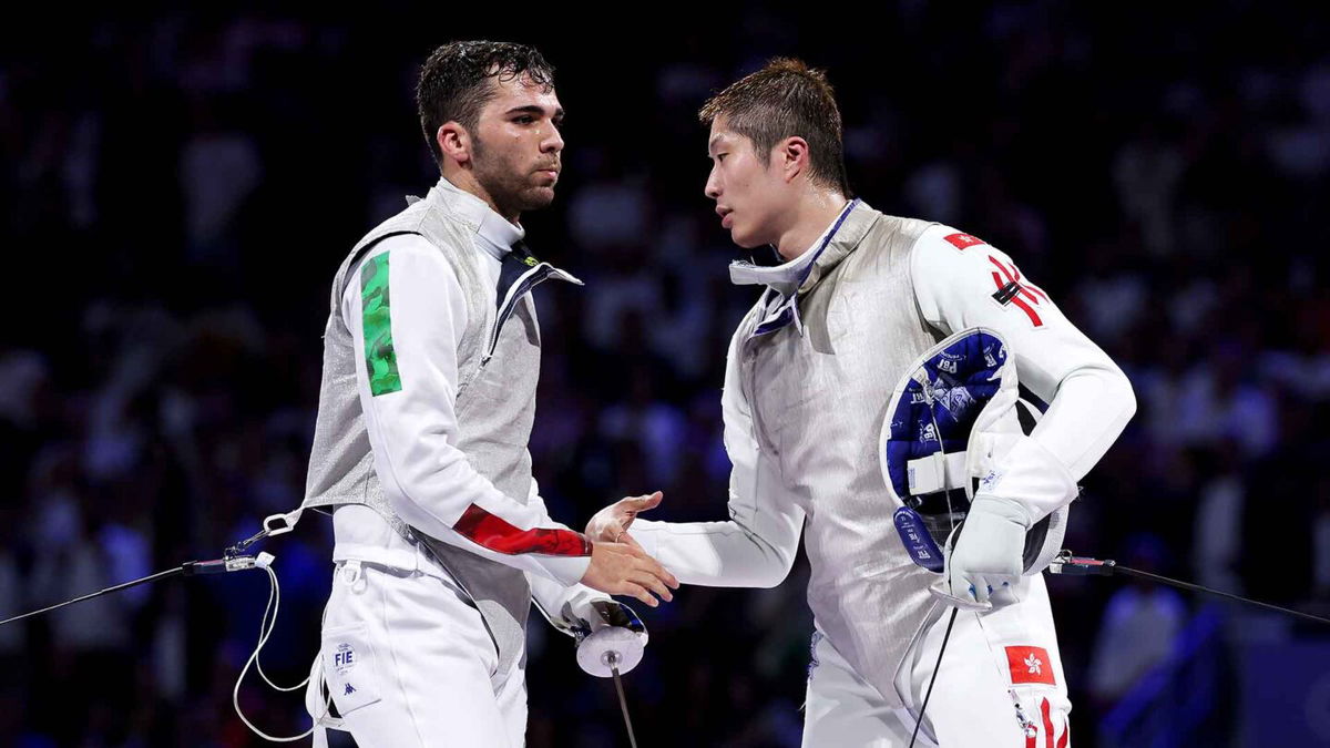 Cheung Ka-Long of Hong Kong (R) congratulates Filippo Macchi of  Italy react after the fencing men's foil individual gold medal bout on day three of the 2024 Paris Olympics at Grand Palais