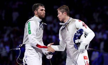 Cheung Ka-Long of Hong Kong (R) congratulates Filippo Macchi of  Italy react after the fencing men's foil individual gold medal bout on day three of the 2024 Paris Olympics at Grand Palais