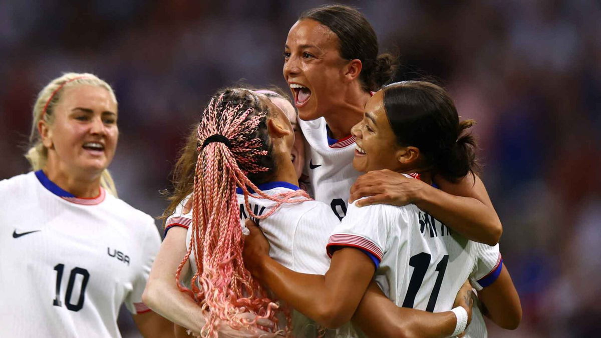 USWNT players celebrate after scoring a goal.