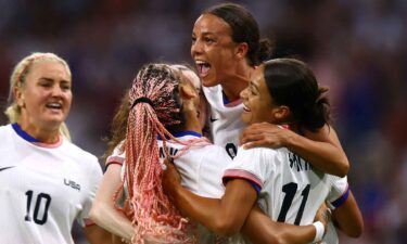 USWNT players celebrate after scoring a goal.