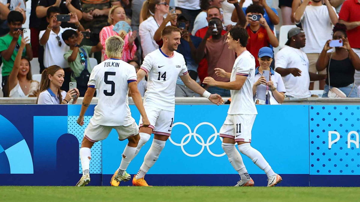 USMNT players celebrate after scoring a goal.