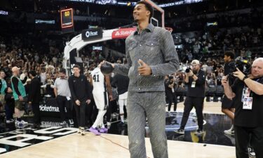 San Antonio Spurs forward Victor Wembanyama prepares to throw a ball to fans after the final game of the season.