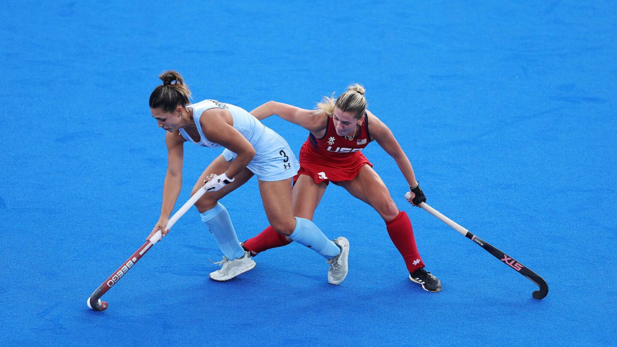 Agustina Gorzelany of Team Argentina runs with the ball whilst under pressure from Ashley Sessa of Team United States during the Women's Pool B match between Argentina and United States on day one of the Olympic Games Paris 2024 at Stade Yves Du Manoir on July 27