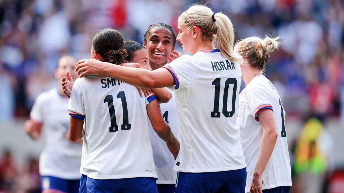 Players from the USWNT celebrate after scoring a goal.