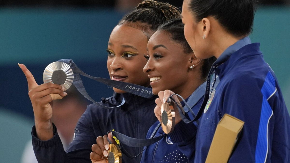 Rebeca Andrade of Brazil and Simone Biles and Sunisa Lee of the United States pose for a photo with their medals in the women's gymnastics all-around during the 2024 Paris Olympics.