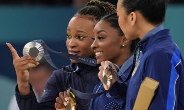 Rebeca Andrade of Brazil and Simone Biles and Sunisa Lee of the United States pose for a photo with their medals in the women's gymnastics all-around during the 2024 Paris Olympics.