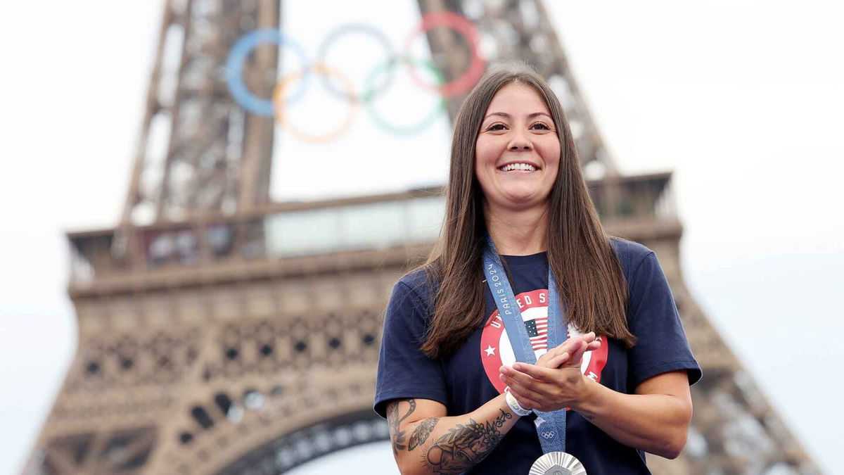 Perris Benegas smiles in front of the Eiffel Tower after wining silver in the women's BMX freestyle event.