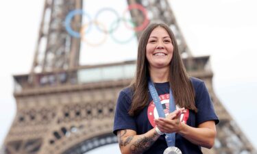 Perris Benegas smiles in front of the Eiffel Tower after wining silver in the women's BMX freestyle event.