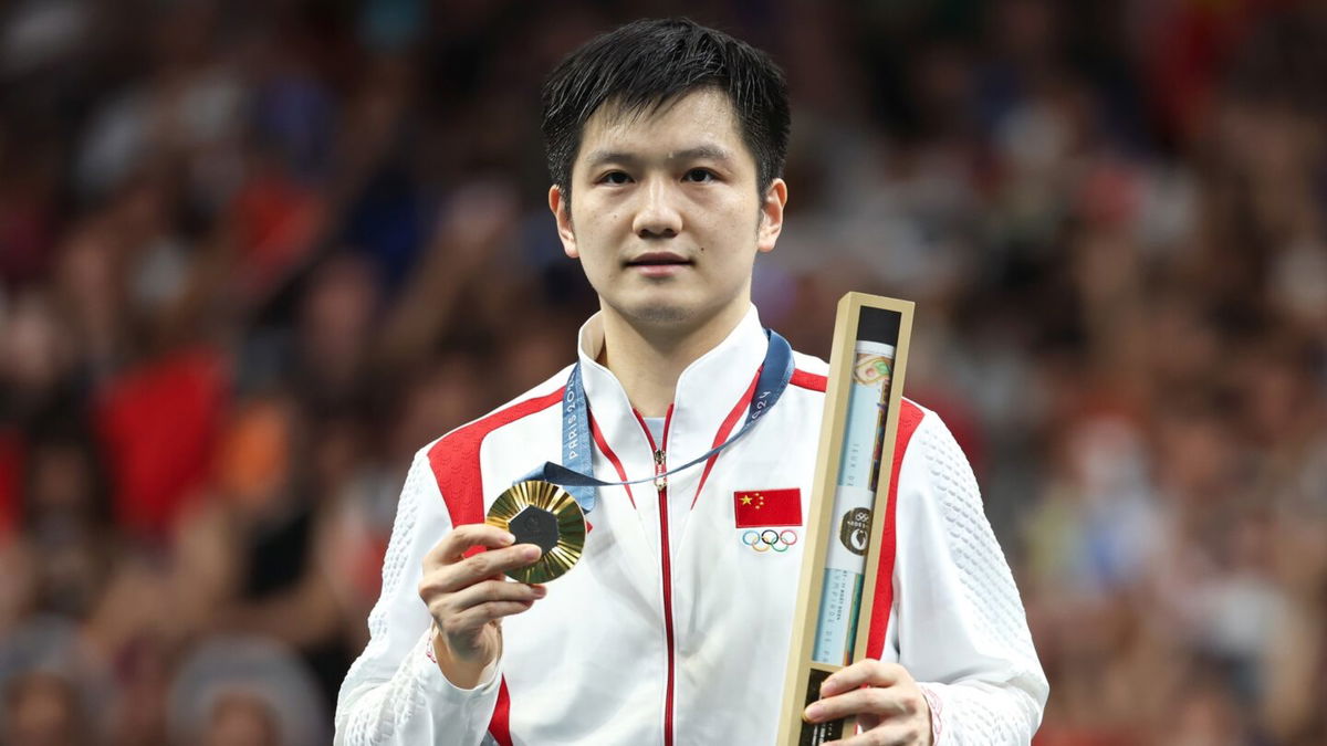 Fan Zhendong of China poses with his gold medal in men's table tennis