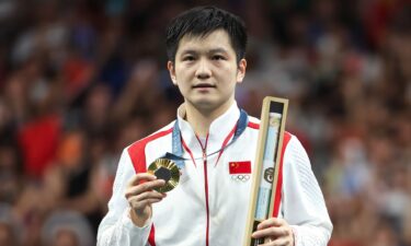 Fan Zhendong of China poses with his gold medal in men's table tennis