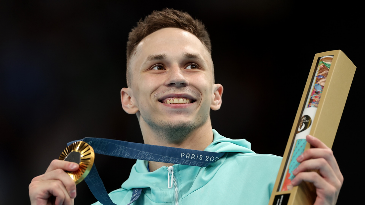 Gold medalist Ivan Litvinovich poses on the podium during the medal ceremony for the trampoline gymnastics men's final.