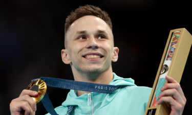 Gold medalist Ivan Litvinovich poses on the podium during the medal ceremony for the trampoline gymnastics men's final.