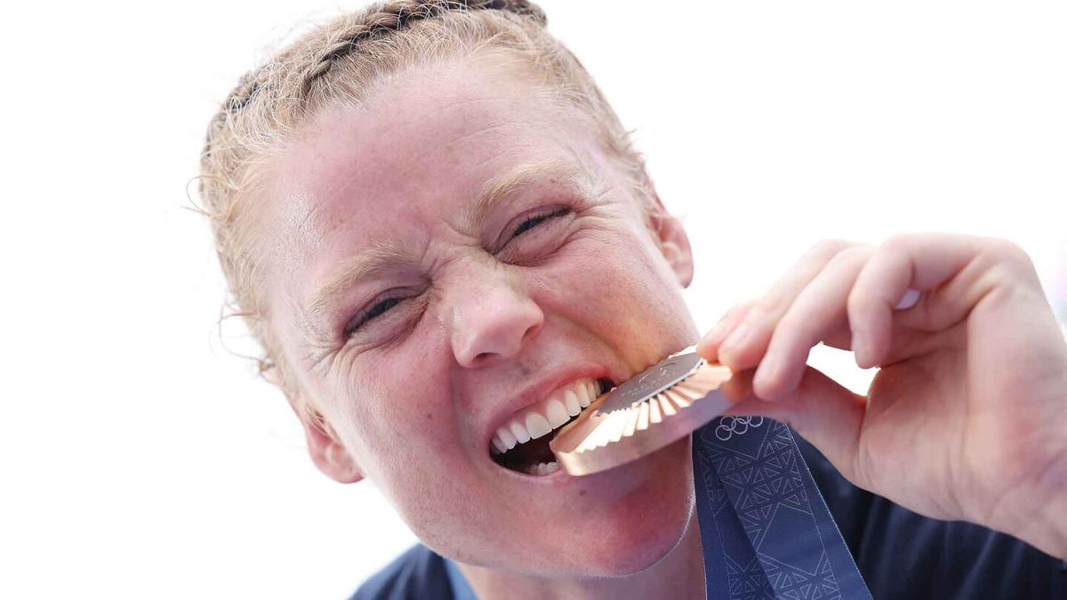 Alev Kelter takes a playful bite of her bronze medal.