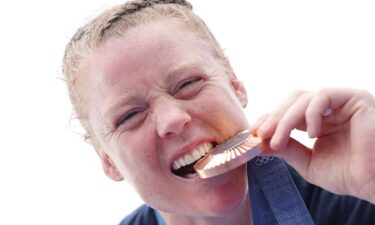 Alev Kelter takes a playful bite of her bronze medal.