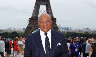 Mike Tirico poses near the Eiffel Tower during the Paris Olympic Games