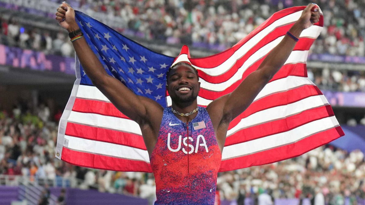 Noah Lyles holds up American flag