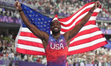 Noah Lyles holds up American flag