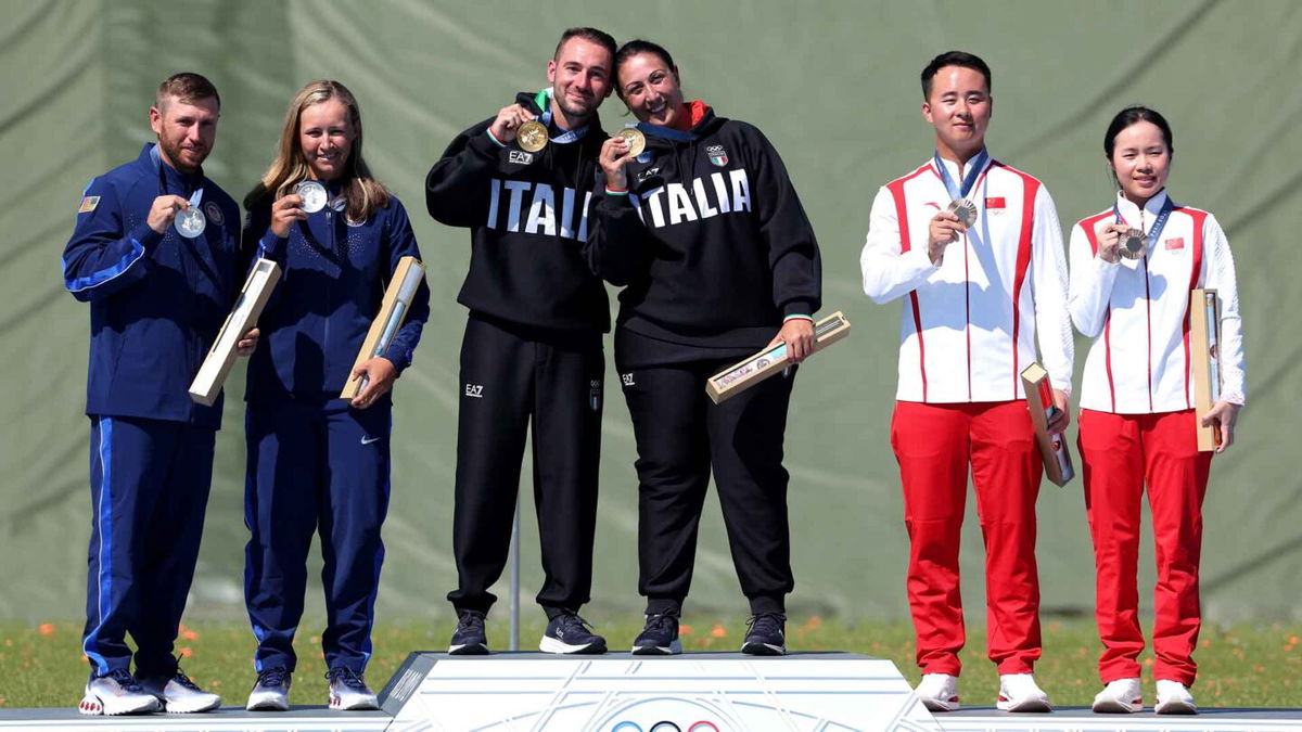 Shooting athletes pose with medals in mixed team skeet