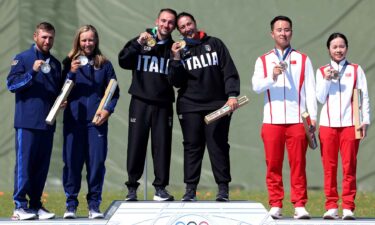 Shooting athletes pose with medals in mixed team skeet