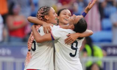 USWNT players celebrate after scoring a goal.