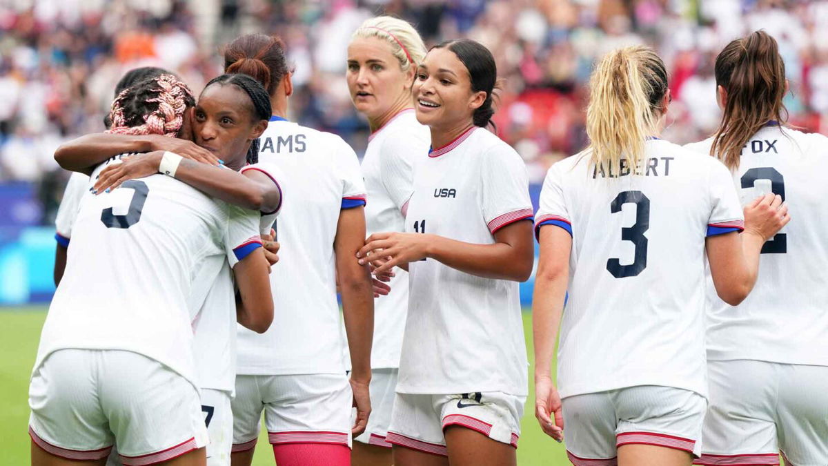 USWNT players celebrate after scoring a goal.