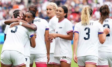 USWNT players celebrate after scoring a goal.