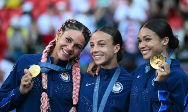 USWNT players pose with gold medals