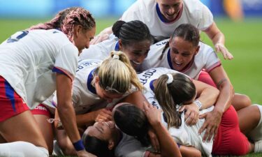 USWNT players celebrate after scoring a goal.