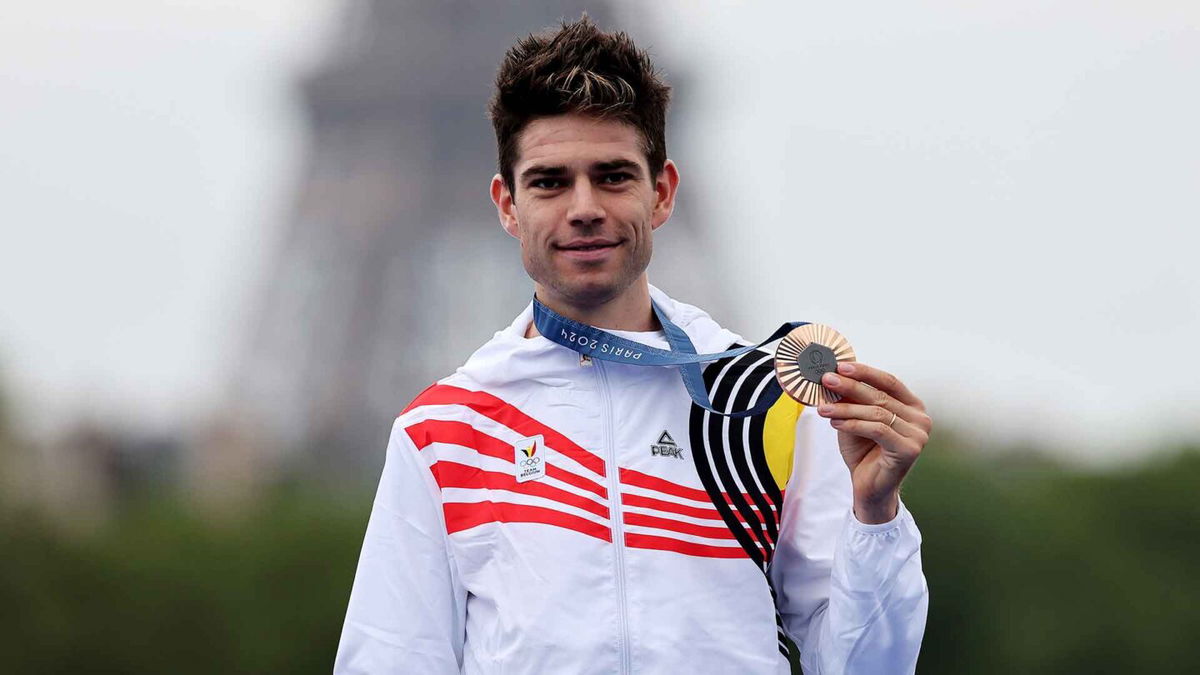 Wout Van Aert poses with a medal.