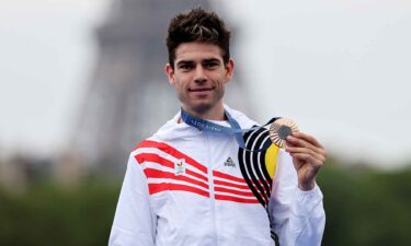 Wout Van Aert poses with a medal.