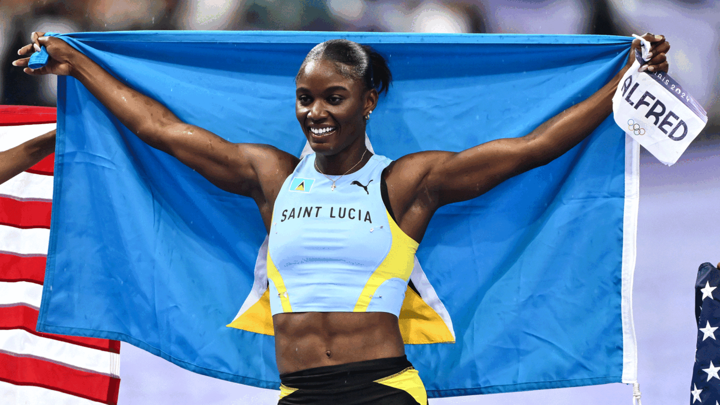 Julien Alfred holds up the Saint Lucia flag following her surprise 100m win