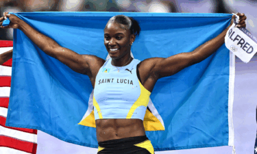 Julien Alfred holds up the Saint Lucia flag following her surprise 100m win