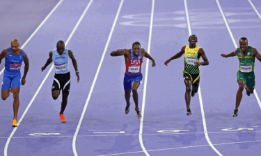 Noah Lyles surges toward the finish line in his photo finish win in the 100m dash at the Olympics