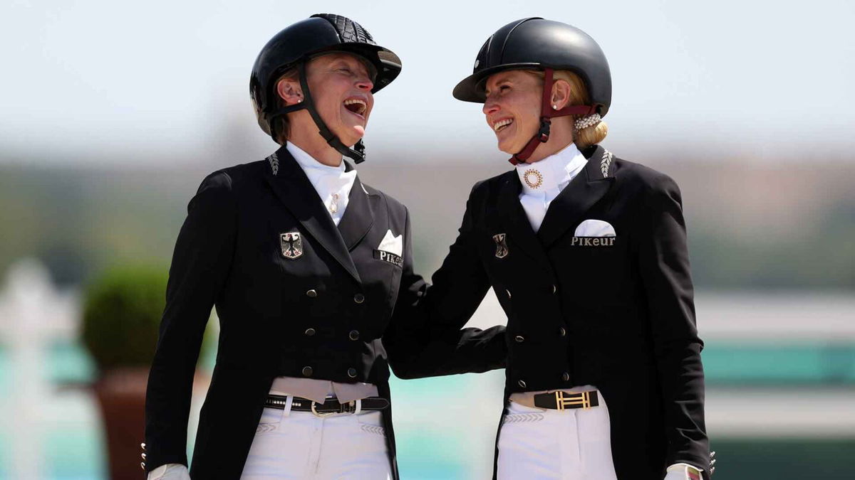 Silver medalist Isabell Werth of Team Germany (L) and gold medalist Jessica Von Bredow-Werndl of Team Germany interact during the medal ceremony for the Dressage Individual Grand Prix Freestyle in Versailles