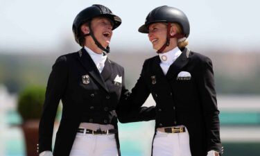 Silver medalist Isabell Werth of Team Germany (L) and gold medalist Jessica Von Bredow-Werndl of Team Germany interact during the medal ceremony for the Dressage Individual Grand Prix Freestyle in Versailles