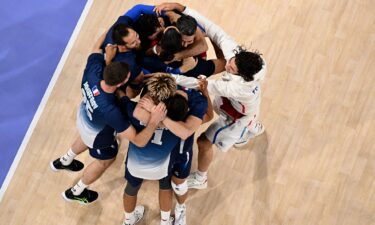 France's players celebrate after winning the men's volleyball semi-final match between Italy and France