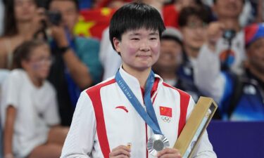 China's silver medalist He Bingjiao celebrates on the podium during the medal ceremony after the Badminton - Women's Singles Gold Medal Match