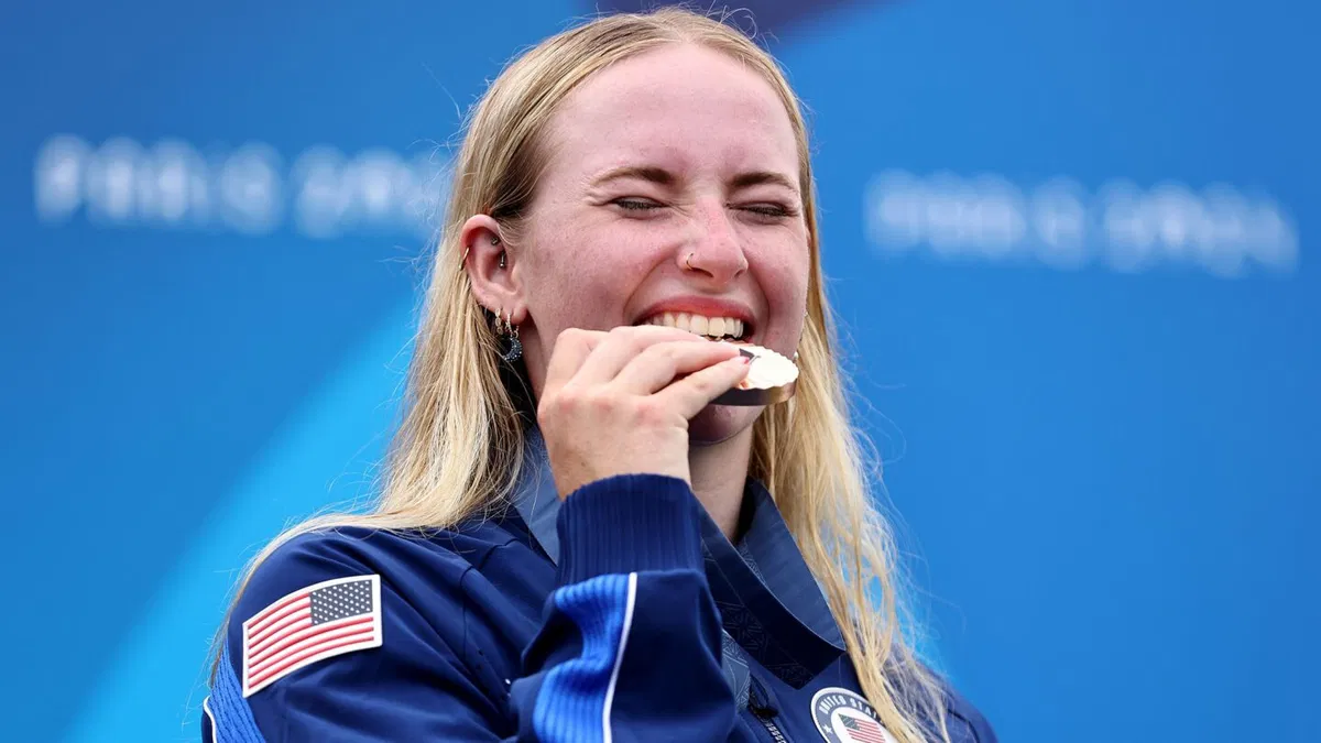 Bronze medalist Evy Leibfarth of Team United States bites her medal on the podium during the Women's Canoe Slalom Single medal ceremony