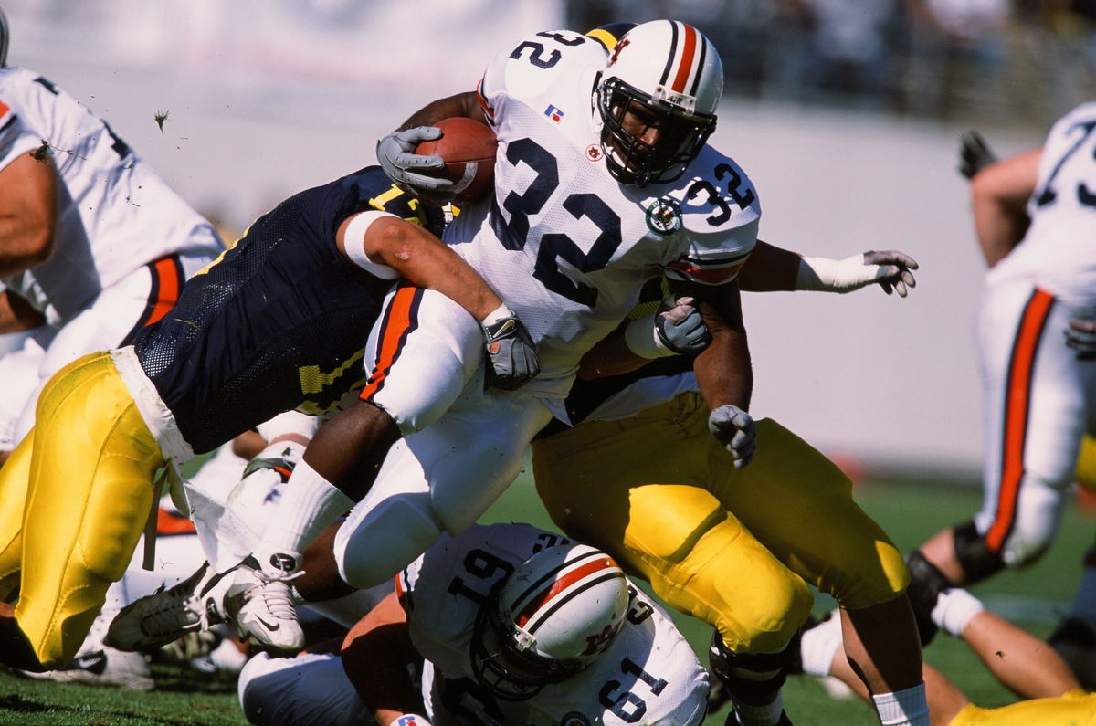 <i>The Sporting News/Getty Images via CNN Newsource</i><br/>Auburn's Rudi Johnson runs with the ball against Michigan in 2001.