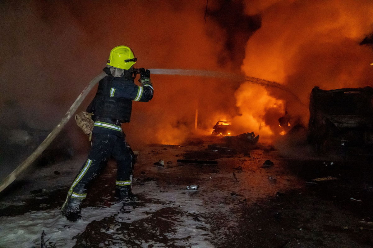 Rescue workers put out a fire at a residential building damaged by a Russian strike in Kharkiv