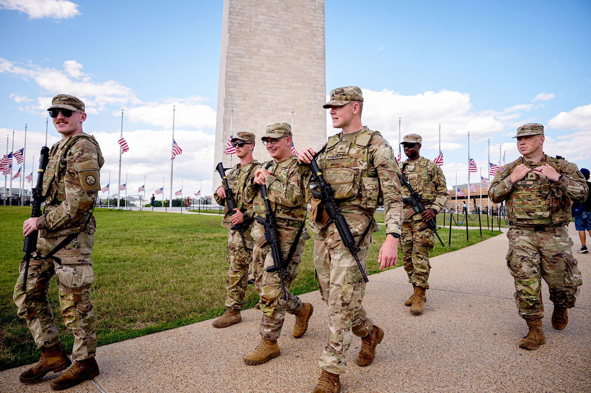 The Washington Monument is visible as armed members of the National Guard patrol the National Mall on August 27 in Washington