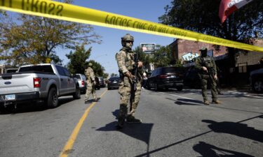 A person is detained as residents of Chicago's Brighton Park neighborhood confront US Border Patrol and other law enforcement agents at a gas station after Immigration and Customs Enforcement allegedly detained an unidentified man riding in his car on October 4.